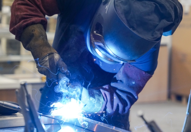 Bespoke steelwork with man and welders mask